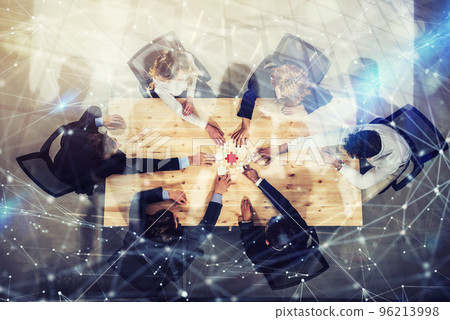 Businessmen working together to build a colored puzzle. Concept of teamwork, partnership, integration and startup. Double exposure with network effects Businessmen working together to build a colored puzzle. Concept of teamwork, partnership, integration and startup. Double exposure with network effects 96213998