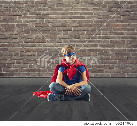 Superhero kid sitting on a wall that dreams Superhero kid sitting on a wall that dreams 96214005
