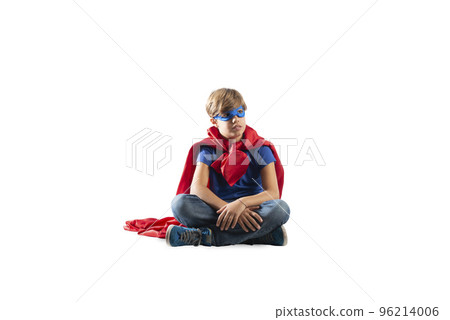 Superhero kid sitting on a wall that dreams. Isolated on white background Superhero kid sitting on a wall that dreams. Isolated on white background 96214006