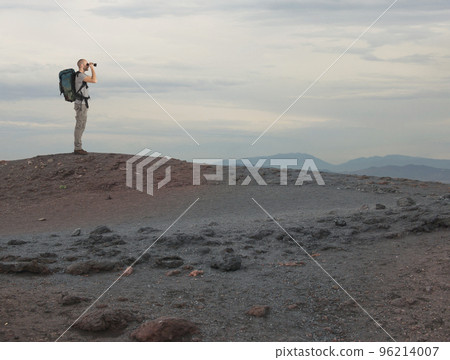 Explorer with binocular searches something in a desert Explorer with binocular searches something in a desert 96214007