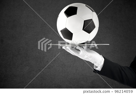 Waiter that holds a tray with soccer ball. Concept of first class service on soccer Waiter that holds a tray with soccer ball. Concept of first class service on soccer 96214059