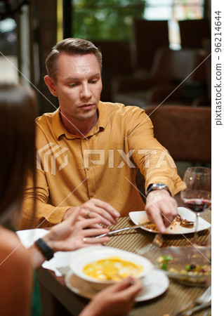 Serious man asking wife if she will finish her salad Serious man asking wife if she will finish her salad 96214644