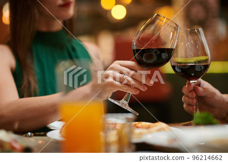 Couple celebrating anniversary in fancy restaurant, toasting with wine glasses 96214662