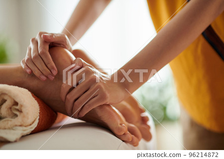 Closeup image of woman receiving relaxing feet massage with oils 96214872