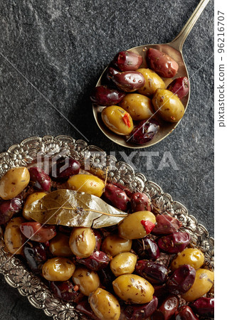Spicy olives on a black stone table. Spicy olives on a black stone table. 96216707