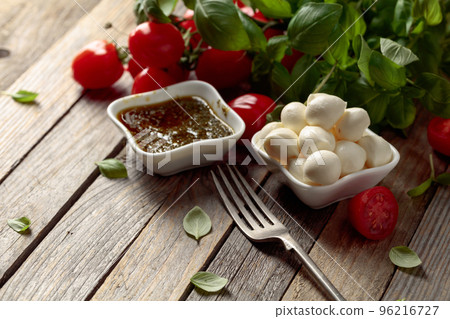Mozzarella cheese with basil, pesto sauce, and tomatoes. Mozzarella cheese with basil, pesto sauce, and tomatoes. 96216727