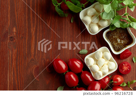 Mozzarella cheese with basil, pesto sauce, and tomatoes. 96216728
