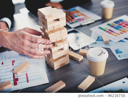Teamwork of partners. Concept of integration and startup with a small construction of wooden toy 96216738