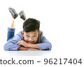 A 10-year-old Asian boy in a casual jacket is lying on the floor and smiling happily in a good mood looking at the camera. Positive concepts for children and young men's lifestyles. 96217404