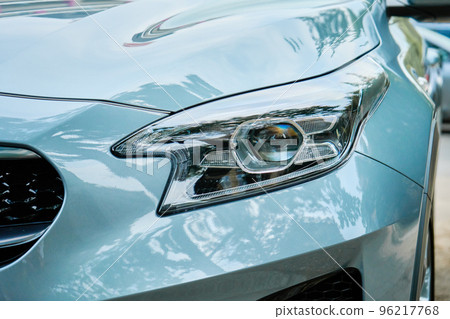 Moder car headlight with led lamp outdoors. Part of new car, turquoise color 96217768