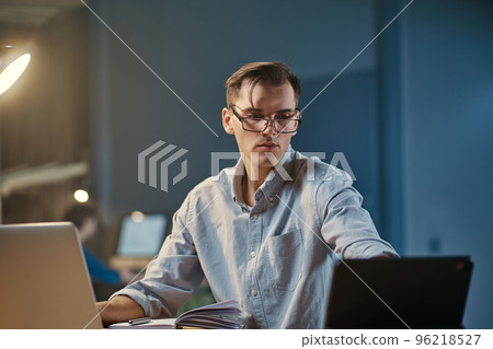 young employee works overtime in the office at night. young employee works overtime in the office at night. 96218527