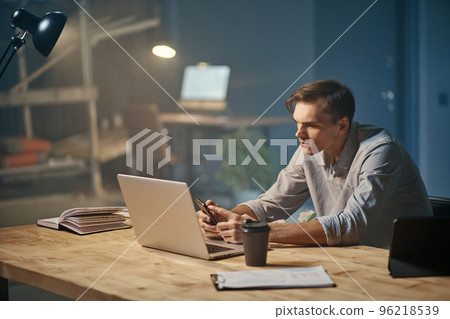 motivated young businessman works in the office at night . motivated young businessman works in the office at night . 96218539