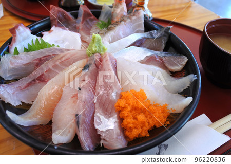 Bowl of rice topped with sashimi  96220836