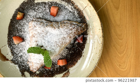 Apple turnovers dusted with icing sugar with strawberry chunks and chocolate sauce Apple turnovers dusted with icing sugar with strawberry chunks and chocolate sauce 96221987