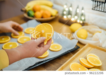 How to Dry Orange Slices for Eco friendly zero waste Holiday Decor. Close up Process of Drying Orange Slices in Oven. Woman cutting slices of orange and citrus fruits for drying in oven in kitchen How to Dry Orange Slices for Eco friendly zero waste Holiday Decor. Close up Process of Drying Orange Slices in Oven. Woman cutting slices of orange and citrus fruits for drying in oven in kitchen 96222206