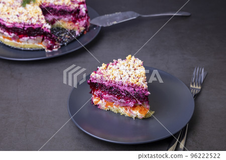 Herring salad under a fur coat. Traditional Russian multilayered salad from herring, beets, potatoes, carrots and eggs. Close-up, grey background. Herring salad under a fur coat. Traditional Russian multilayered salad from herring, beets, potatoes, carrots and eggs. Close-up, grey background. 96222522