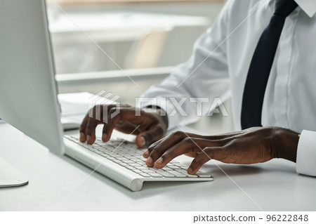 Close-up of African American businessman typing on keyboard while working on computer at office 96222848