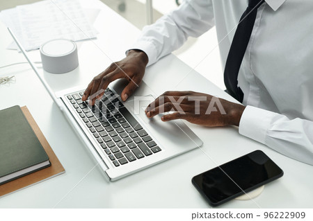 High angle view of African American businessman sitting at table and typing on laptop during her work at office 96222909
