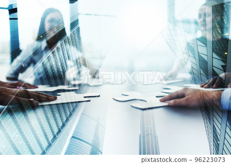 Business teamwork at the office. Workers join puzzle pieces on the desk. Partnership concept Business teamwork at the office. Workers join puzzle pieces on the desk. Partnership concept 96223073