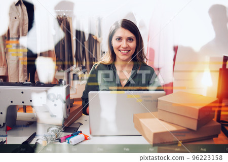 Seamstress works to new clothes ordered by internet client 96223158