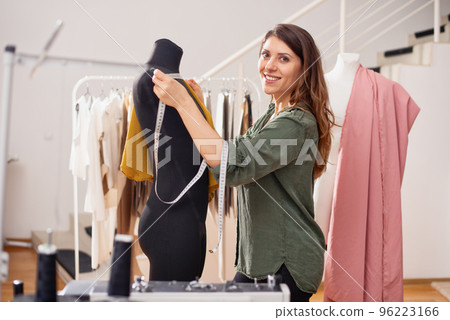 Seamstress works to new clothes ordered by internet client Seamstress works to new clothes ordered by internet client 96223166