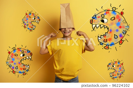 Child is afraid due to covid19 virus attack and hides his head inside a shopping bag 96224102