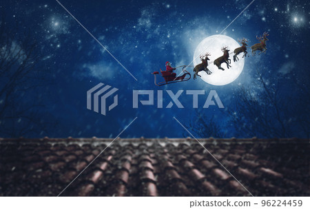 Santa Claus on his sleigh, pulled by reindeer, flying at night to deliver gifts 96224459