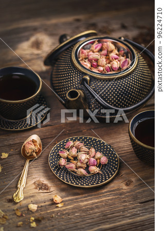 Cup of hot tea and iron teapot 96224710