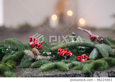 Hot tub with spa in winter with snow and decorated candles. Christmas twigs with guelder rose and pine cones 96224861