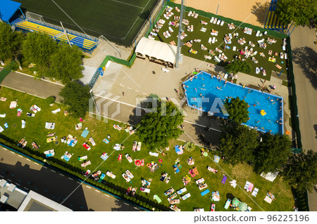 Top view of an outdoor place for people to relax where there is a swimming pool and a lot of sun beds 96225196