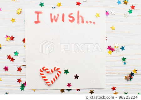 notebook with wish list on vintage wooden table with candy canes. christmas planning concept. notebook with wish list on vintage wooden table with candy canes. christmas planning concept. 96225224