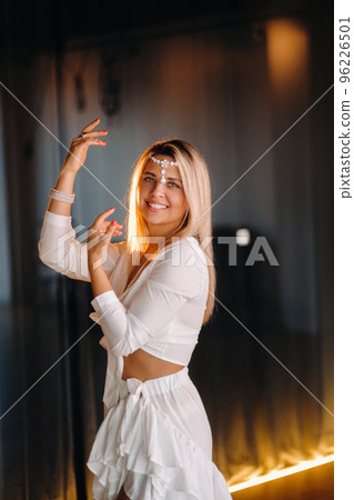 Beautiful smiling girl in a white dress dancing in the gym Beautiful smiling girl in a white dress dancing in the gym 96226501