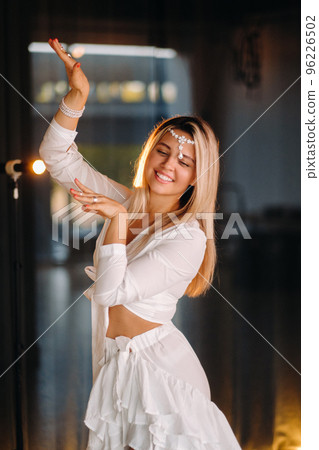Beautiful smiling girl in a white dress dancing in the gym Beautiful smiling girl in a white dress dancing in the gym 96226502