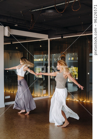 Two women in sportswear are doing dance yoga in the gym Two women in sportswear are doing dance yoga in the gym 96226571
