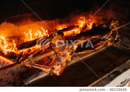 The lamb is cooked entirely on a spit on the fire. Cooking The lamb is cooked entirely on a spit on the fire. Cooking 96226686