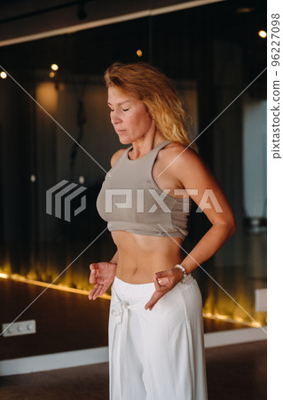 a woman does breathing exercises in the fitness room. Home sports training for the muscles of the press a woman does breathing exercises in the fitness room. Home sports training for the muscles of the press 96227098