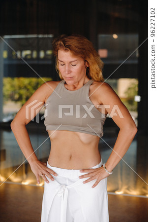 a woman does breathing exercises in the fitness room. Home sports training for the muscles of the press a woman does breathing exercises in the fitness room. Home sports training for the muscles of the press 96227102