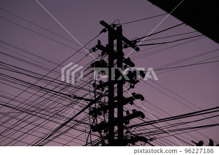 Overgrown wires on electric poles at dusk. 96227186