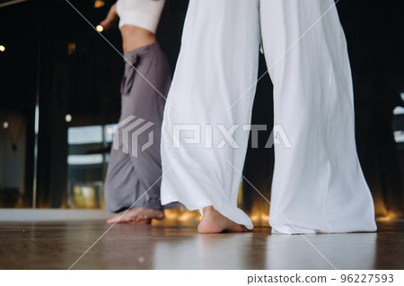 Close-up of dancing legs of women in sportswear doing dance yoga in the gym Close-up of dancing legs of women in sportswear doing dance yoga in the gym 96227593