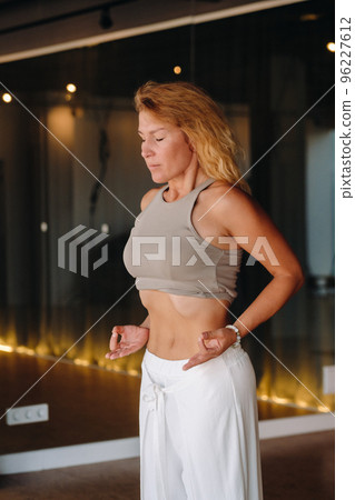 a woman does breathing exercises in the fitness room. Home sports training for the muscles of the press a woman does breathing exercises in the fitness room. Home sports training for the muscles of the press 96227612
