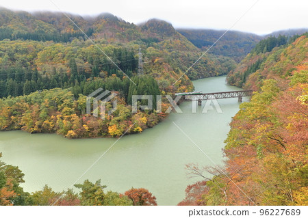A train running on the Tadami Line in fall foliage A train running on the Tadami Line in fall foliage 96227689
