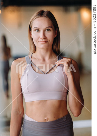 Portrait of a girl in the gym. A coach in sportswear is standing in the gym Portrait of a girl in the gym. A coach in sportswear is standing in the gym 96227893