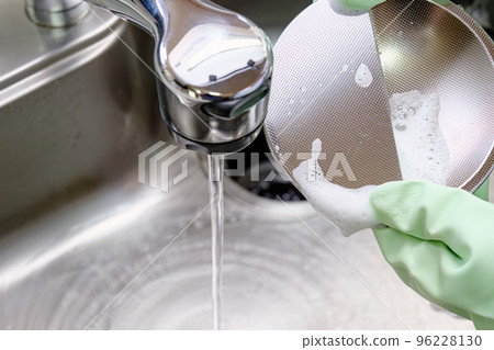 Housewife cleaning the sink drain 96228130