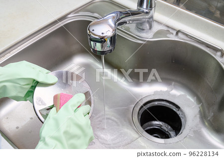 Housewife cleaning the sink drain 96228134