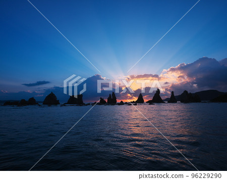Hashigui-iwa rock bathed in the angel ladder of the rising sun Hashigui-iwa rock bathed in the angel ladder of the rising sun 96229290