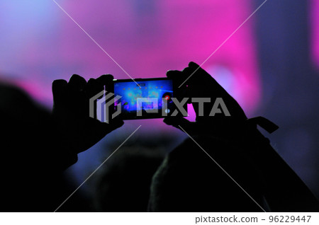 Crowd of people taking photos with smartphones at a concert 96229447