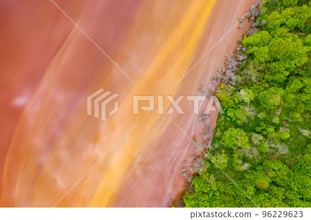 Aerial view of red waste water and green forest 96229623