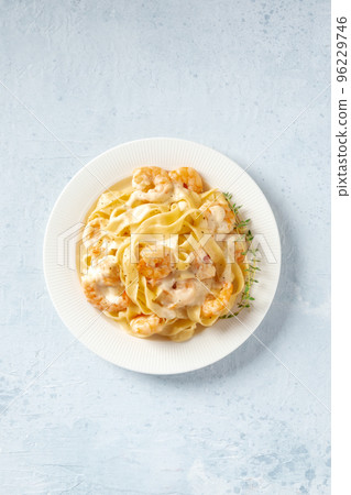 Seafood pasta. Pappardelle with shrimps and cream sauce in a white plate Seafood pasta. Pappardelle with shrimps and cream sauce in a white plate 96229746