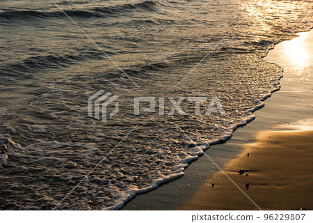 Waves approaching sandy beach during the sunset Waves approaching sandy beach during the sunset 96229807