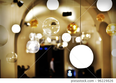 Hanging glass lamps in a room 96229826